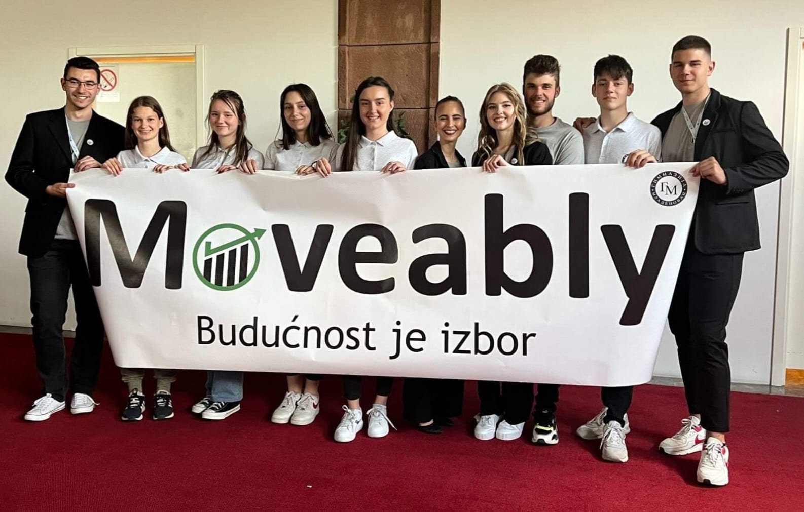 Moveably high school team holding the Moveably banner